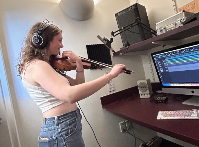 photo of a girl playing violin inside a recording booth
